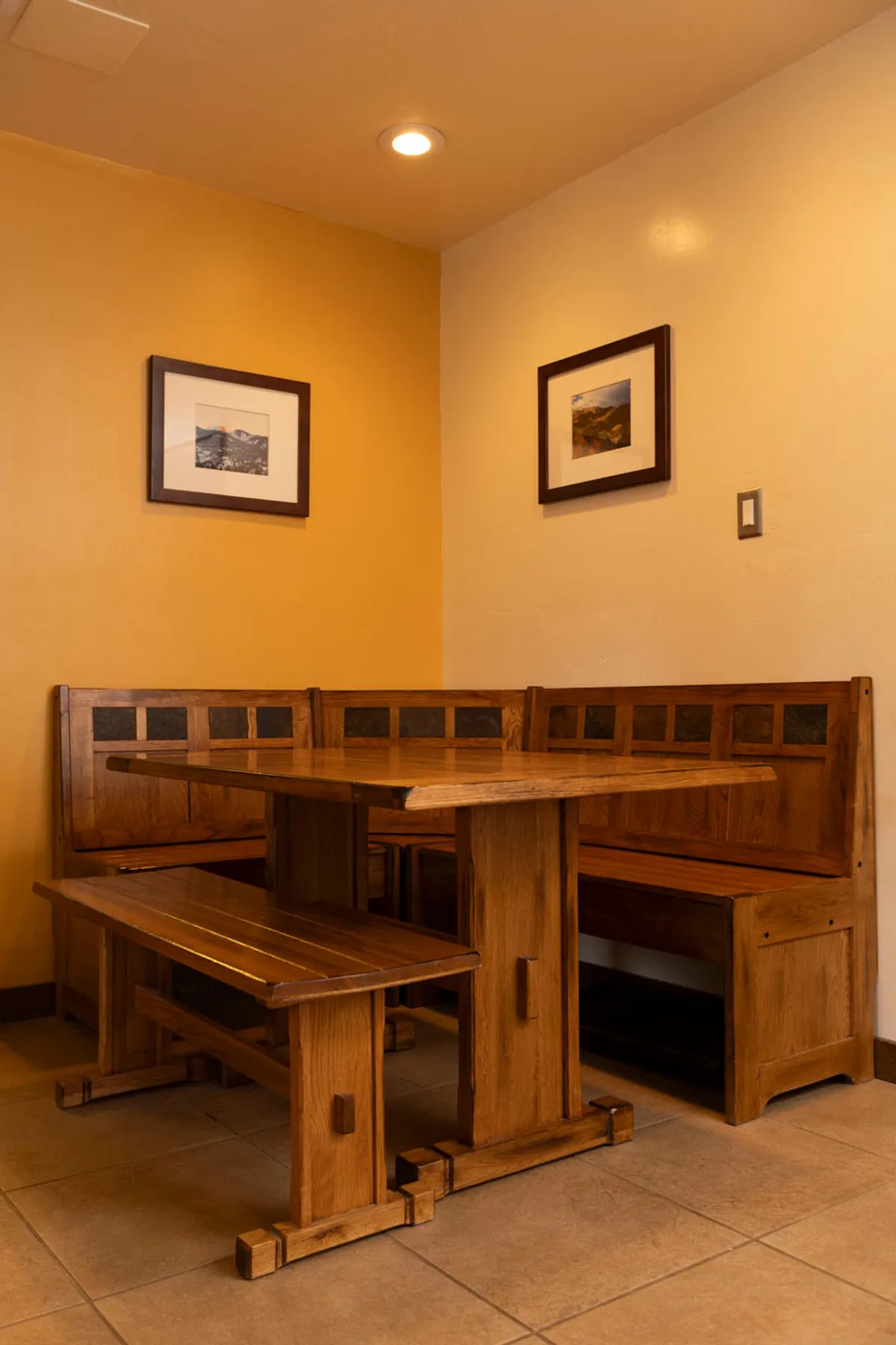 A welcoming dining area with a wooden table and benches, adorned with framed photographs. The setting is perfect for gathering, sharing stories, and enjoying memorable meals together.